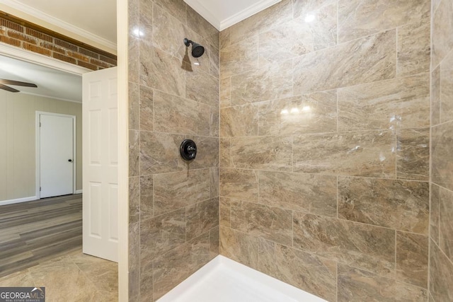 full bath with tiled shower, a ceiling fan, and ornamental molding