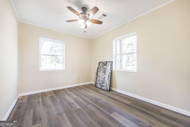 spare room with visible vents, wood finished floors, crown molding, baseboards, and ceiling fan