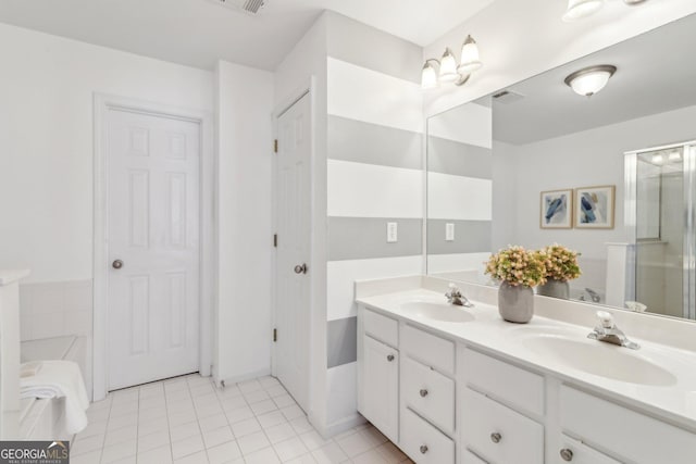 full bathroom featuring double vanity, visible vents, tile patterned flooring, and a sink