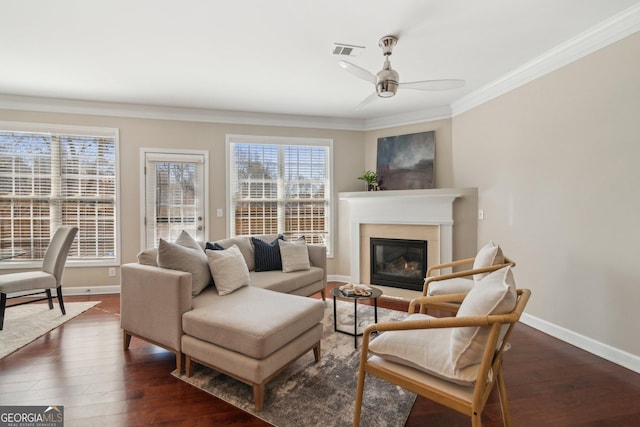 living area featuring dark wood finished floors, visible vents, crown molding, and baseboards