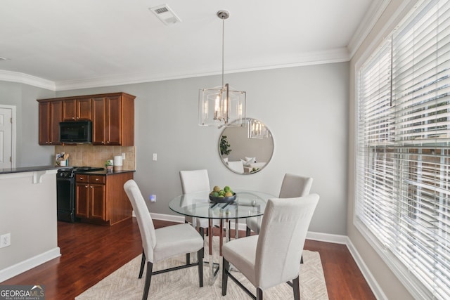 dining room with dark wood finished floors, a notable chandelier, baseboards, and ornamental molding