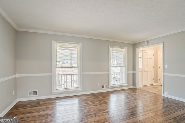 empty room featuring visible vents, a textured ceiling, and hardwood / wood-style flooring