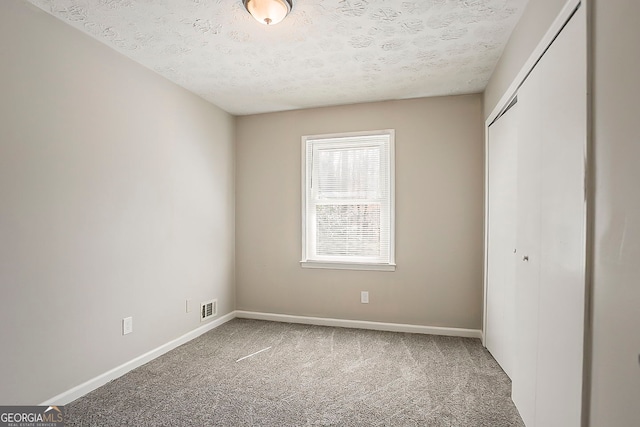 unfurnished bedroom with a closet, visible vents, baseboards, and carpet