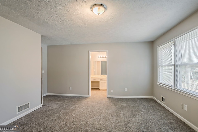 interior space featuring baseboards, visible vents, and a textured ceiling