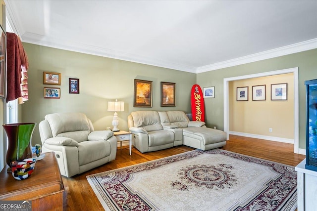 living room with crown molding, baseboards, and wood finished floors