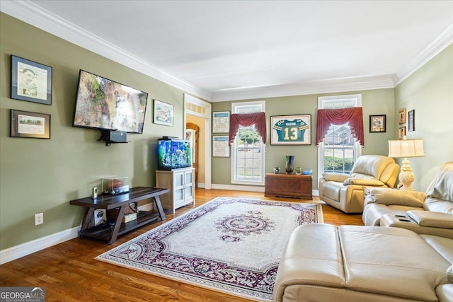 living area featuring baseboards, wood finished floors, and crown molding