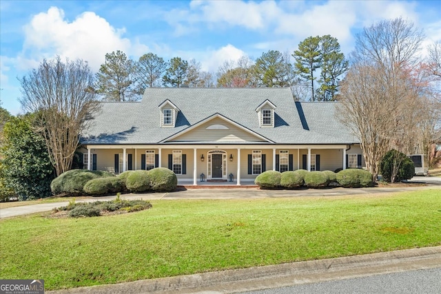 cape cod home with covered porch and a front lawn