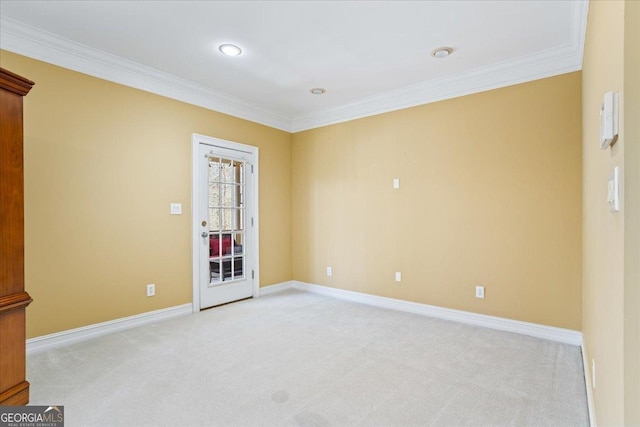 empty room featuring baseboards, light colored carpet, and crown molding