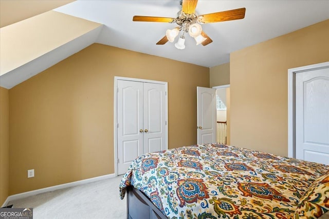 bedroom featuring baseboards, ceiling fan, vaulted ceiling, a closet, and light carpet