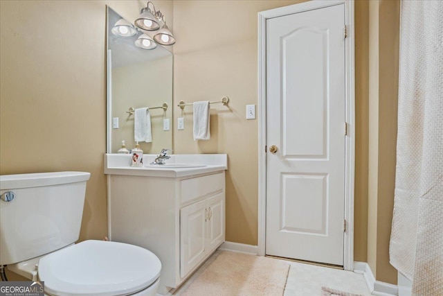 full bathroom with toilet, vanity, and baseboards