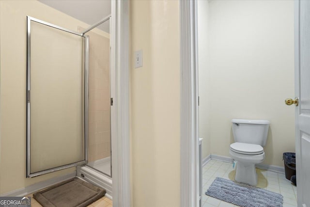 full bathroom with a shower stall, toilet, baseboards, and tile patterned floors