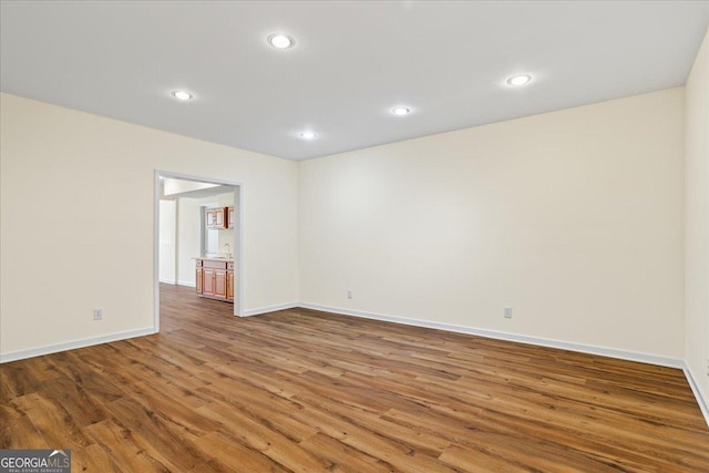 unfurnished room with recessed lighting, baseboards, and wood finished floors