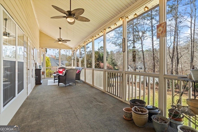 unfurnished sunroom featuring a ceiling fan, lofted ceiling, and wood ceiling