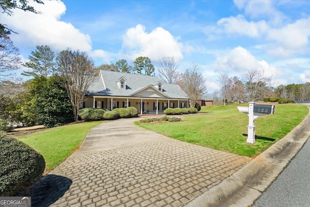 country-style home with aphalt driveway, a porch, and a front lawn