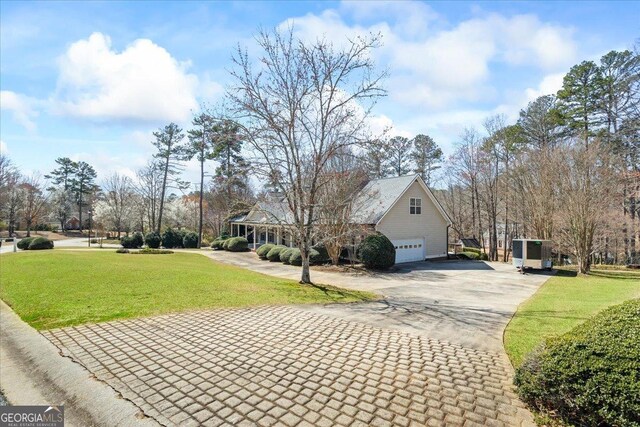 view of front of house with aphalt driveway, an attached garage, and a front yard