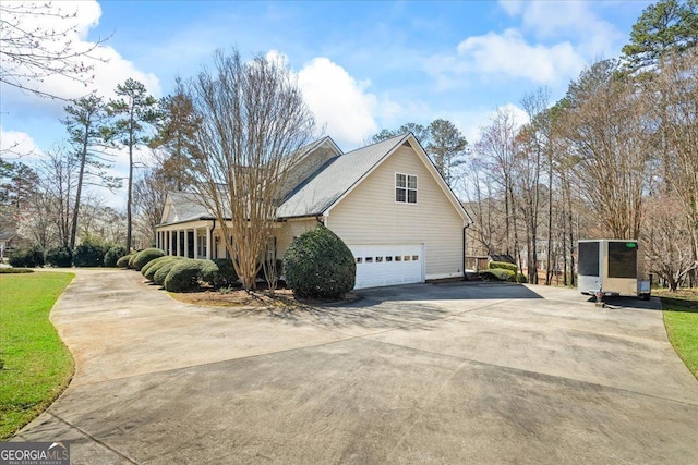 view of side of home with concrete driveway and a garage