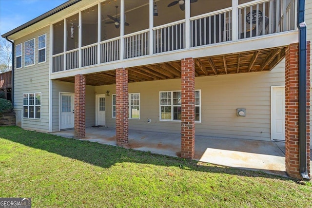 back of property with a sunroom, a lawn, a ceiling fan, and a patio area