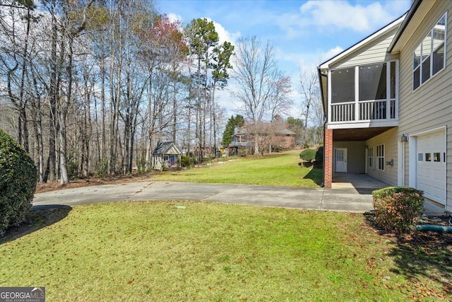 view of yard featuring concrete driveway and a sunroom