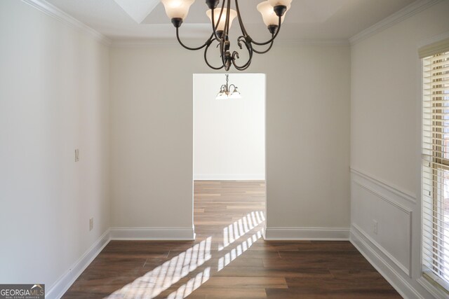 unfurnished dining area featuring a notable chandelier, wood finished floors, and crown molding