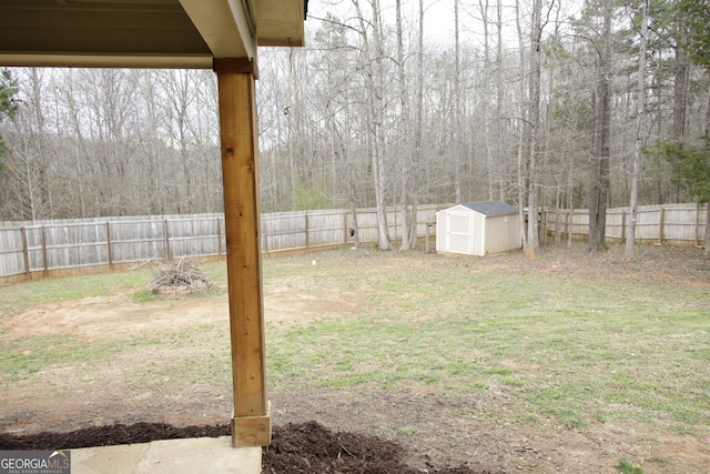 view of yard featuring an outbuilding, a storage shed, and a fenced backyard