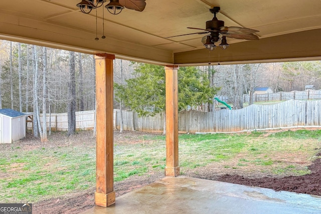 view of patio / terrace featuring a ceiling fan, an outdoor structure, a fenced backyard, and a storage shed