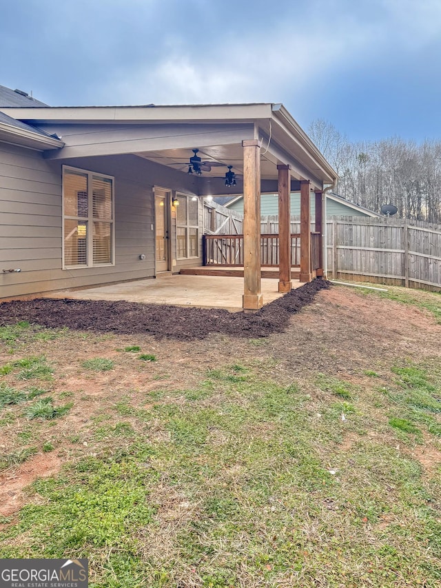 rear view of property featuring a ceiling fan, a patio, and fence