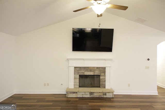 unfurnished living room featuring a stone fireplace, lofted ceiling, and wood finished floors