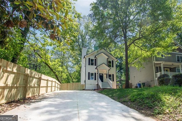 view of front of house featuring a chimney and fence