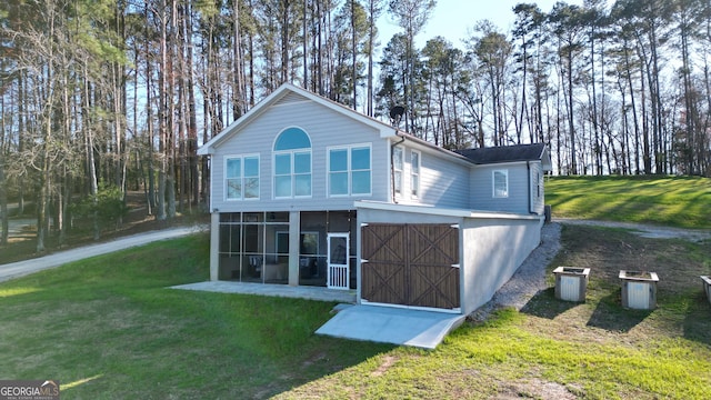 back of house featuring a lawn and a sunroom