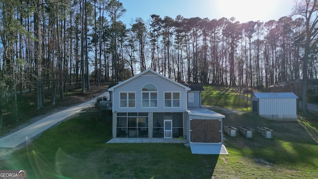 1550 Shady Oaks Ln, Greensboro, GA 30642 - rear view of house featuring a lawn, an outbuilding, a shed, and a sunroom