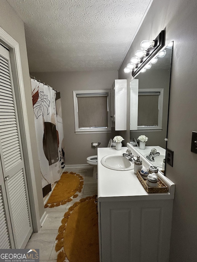 1550 Shady Oaks Ln, Greensboro, GA 30642 - full bath with tile patterned flooring, vanity, toilet, a textured ceiling, and baseboards
