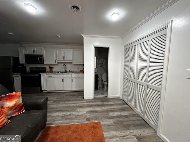 1550 Shady Oaks Ln, Greensboro, GA 30642 - kitchen with crown molding, a sink, baseboards, stainless steel appliances, and light wood-style flooring