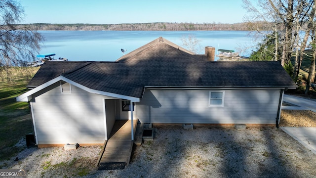 view of front of property featuring a shingled roof and a water view