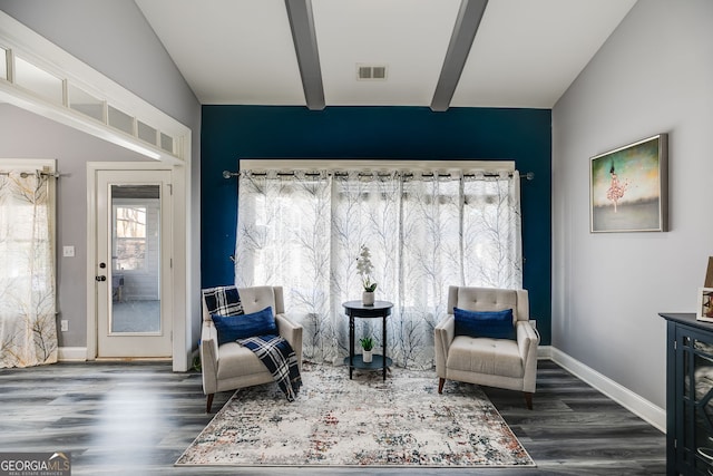 sitting room with vaulted ceiling with beams, wood finished floors, visible vents, and baseboards