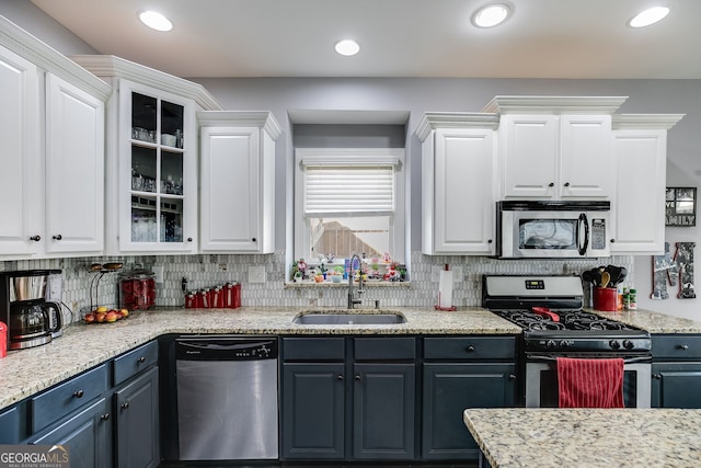 kitchen with white cabinets, tasteful backsplash, appliances with stainless steel finishes, and a sink