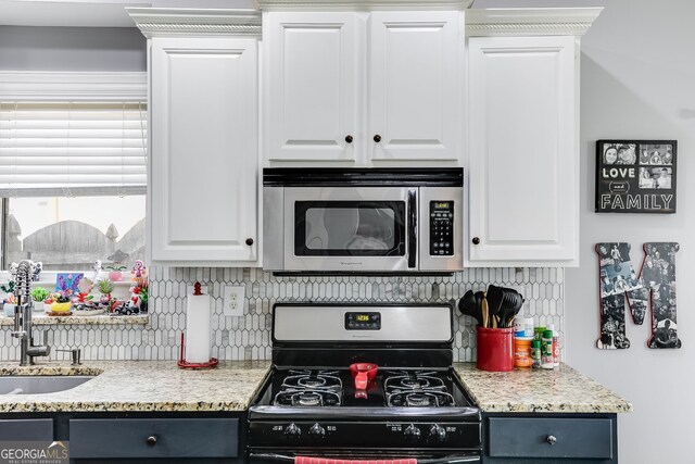 kitchen with a sink, stainless steel appliances, backsplash, and white cabinets