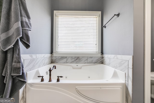 full bathroom featuring toilet and a tub with jets