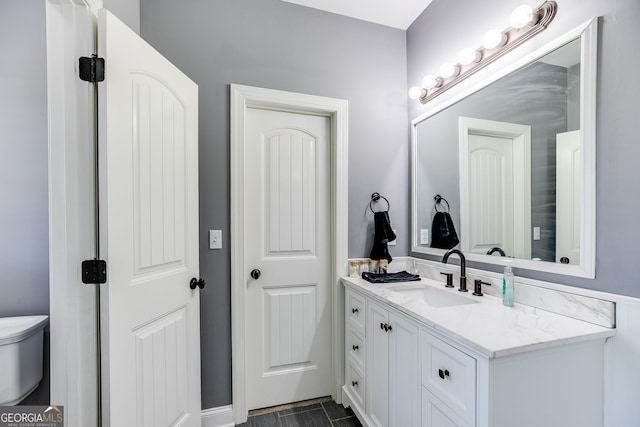 bathroom featuring toilet and vanity