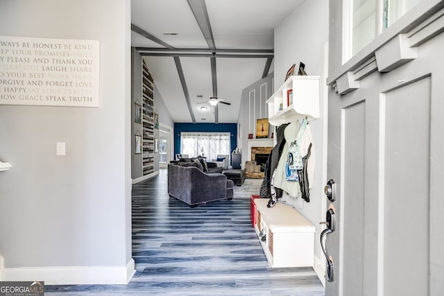 interior space with a fireplace, baseboards, ceiling fan, and wood finished floors