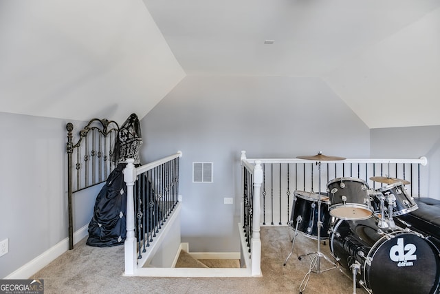 interior space with lofted ceiling, carpet, visible vents, and baseboards