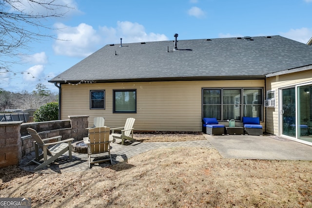 back of property with an outdoor living space with a fire pit, a patio, and a shingled roof