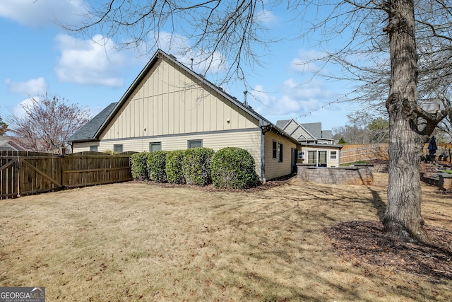 view of property exterior with a yard, fence, and board and batten siding