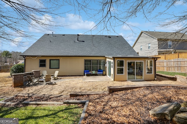 back of property with a patio, a fire pit, roof with shingles, and fence