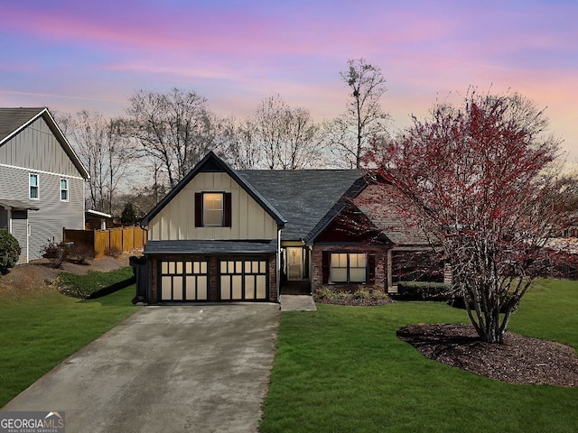 view of front of home with an attached garage, brick siding, concrete driveway, a front lawn, and board and batten siding