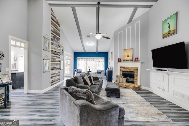 living area featuring a fireplace, high vaulted ceiling, and wood finished floors