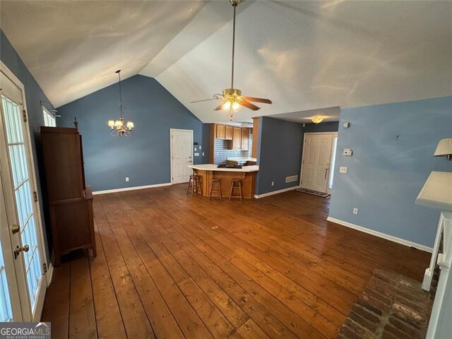 unfurnished living room featuring vaulted ceiling, ceiling fan with notable chandelier, baseboards, and dark wood-style flooring