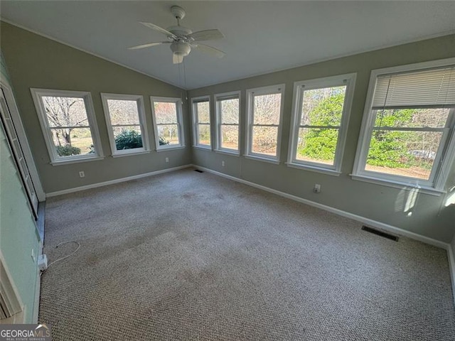 unfurnished sunroom with lofted ceiling, visible vents, a wealth of natural light, and ceiling fan