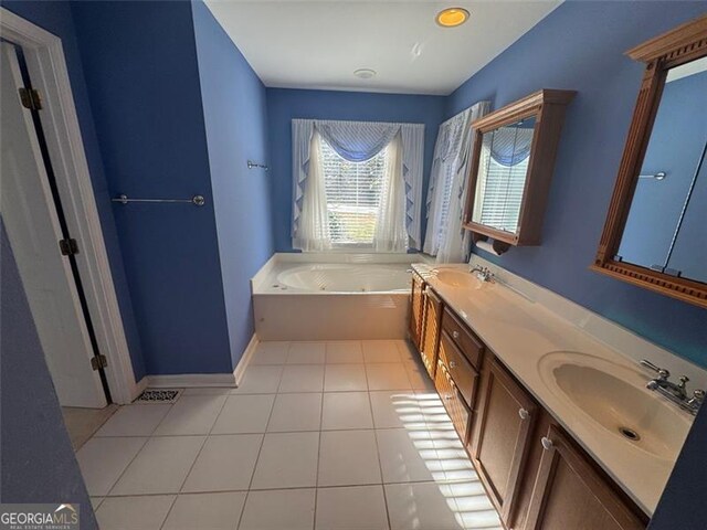 full bath with baseboards, double vanity, a whirlpool tub, a sink, and tile patterned flooring