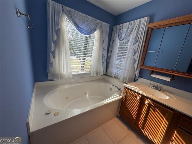 bathroom featuring tile patterned flooring, a jetted tub, and vanity