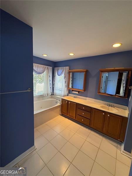 full bath featuring double vanity, recessed lighting, a sink, a garden tub, and tile patterned floors